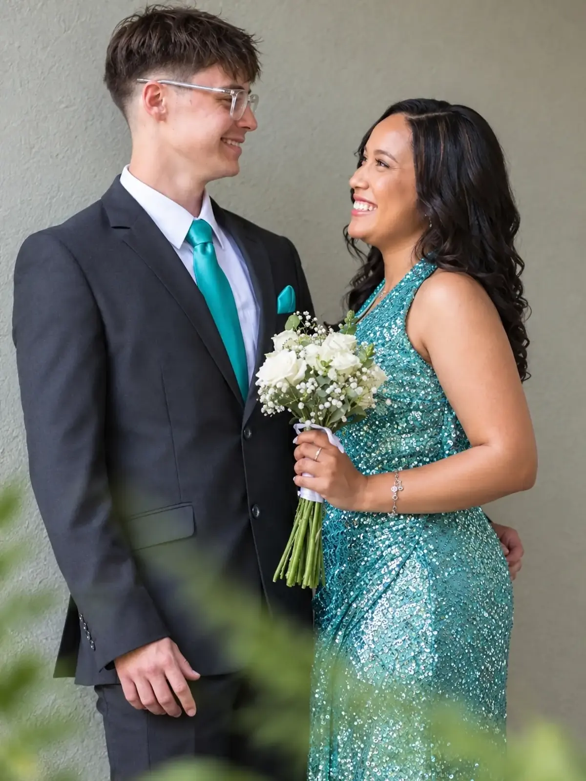 Close portrait of a matric farewell couple, she holds a white rose bouquet